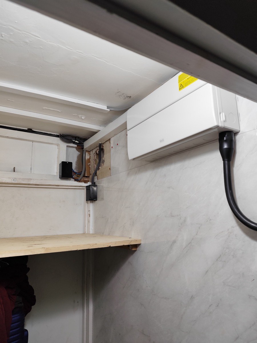 A wall-mounted air-conditioning unit connected to a fused isolator on a marble splashback, wired in by Hi Elec-Tech Solutions in East London.